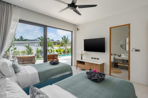 Bedroom with ceiling fan and garden pool view at Villa Solunara, Koh Samui holiday home