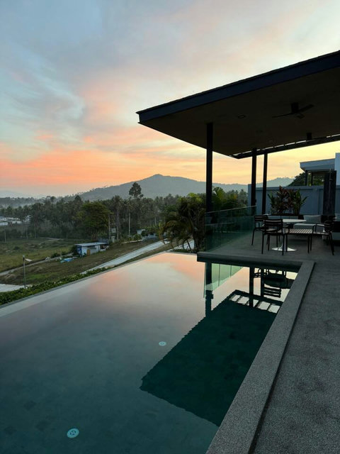 Villa Ombra at night with illuminated pool and modern glass architecture in Mae Nam, Koh Samui