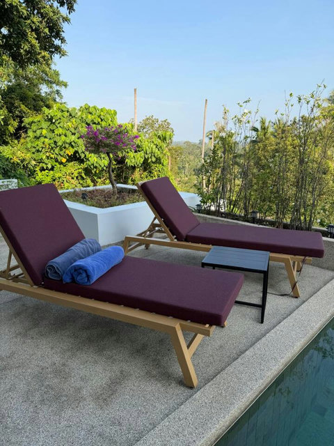 Poolside sun loungers with dramatic sunset views over the mountains at Villa Ombra Koh Samui