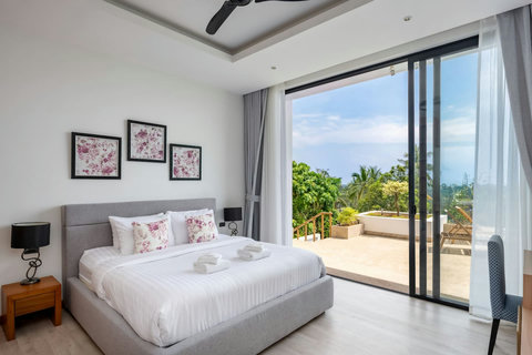 Spacious bedroom with sea views through floor-to-ceiling windows at Villa Ombra Koh Samui