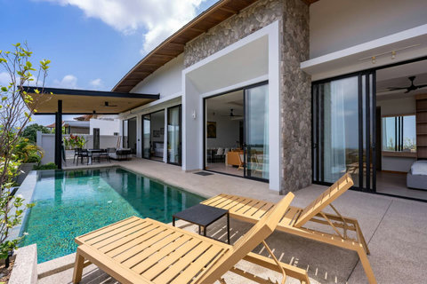 Charming wooden terrace seating area nestled among tropical plants at this Koh Samui rental villa