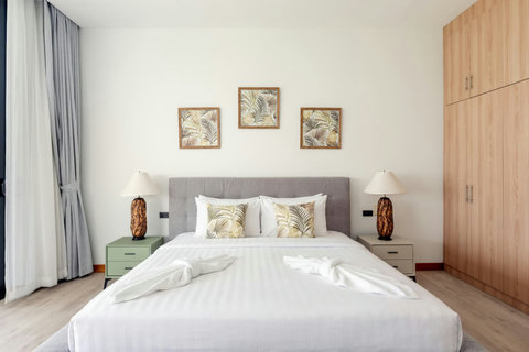 Elegant master suite with premium bedding and decorative headboard at Villa Ombra Thailand