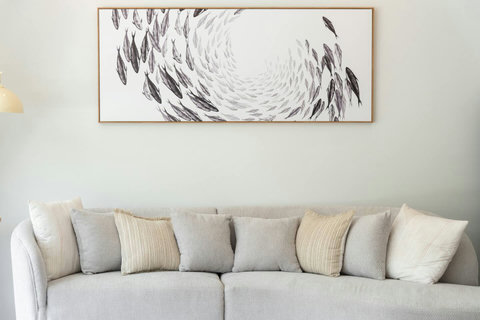 Sink into soft cushions on this spacious sofa. Artistic wall decor and warm lighting create a sophisticated retreat.