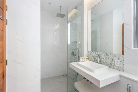 Pamper yourself in this luminous bathroom with twin sinks, spacious shower, and soft marble finishes that feel like a resort.