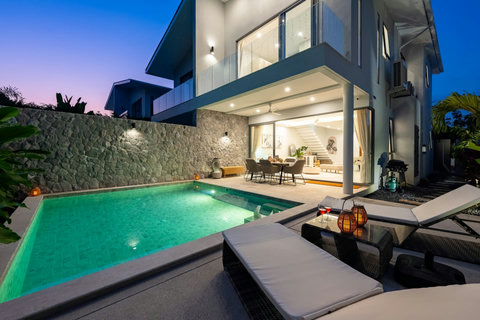 Watch the villa transform as dusk falls—the modern architecture glows softly, revealing terraced levels, stone details, and your private lit pool awaiting a night swim.