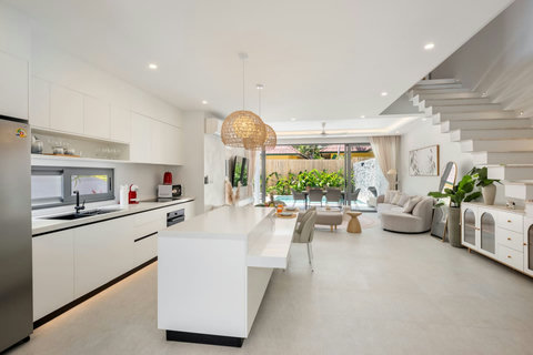 Gather in this bright, flowing space where you can cook, dine, and lounge all in one room. Wide sliding doors open straight to the pool.