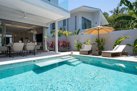 Dive into your own sparkling pool with shallow lounging ledge, then stretch out on sunbeds under the shade umbrella.