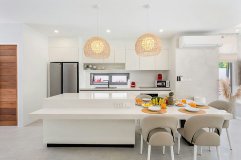 Sit down together at a table dressed for dinner, with warm lighting and easy flow to the kitchen and pool beyond.