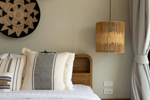 Bedroom corner with rattan pendant and woven wall art