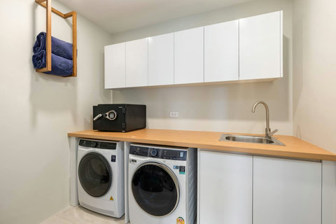 Utility room with washer, dryer and laundry sink