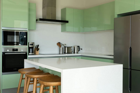 Modern kitchen with green accents and breakfast bar