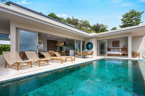 Private pool with sun loungers and open-plan villa exterior