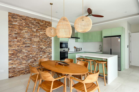 Indoor dining with stone feature wall and rattan pendant lighting