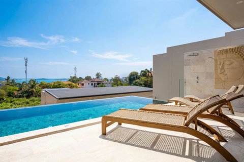 Pool deck with sun loungers overlooking the sea