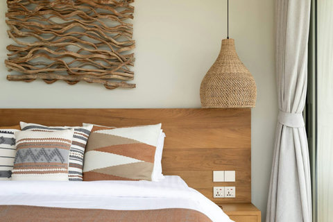 Bedroom detail with driftwood headboard and woven wall art
