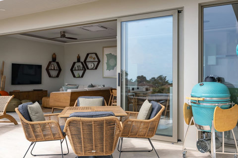 Indoor lounge with hexagonal wall décor and kamado grill view