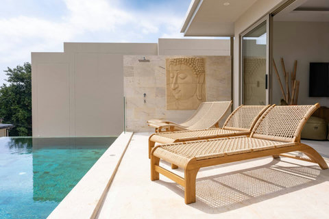 Poolside rattan sun loungers with privacy garden wall