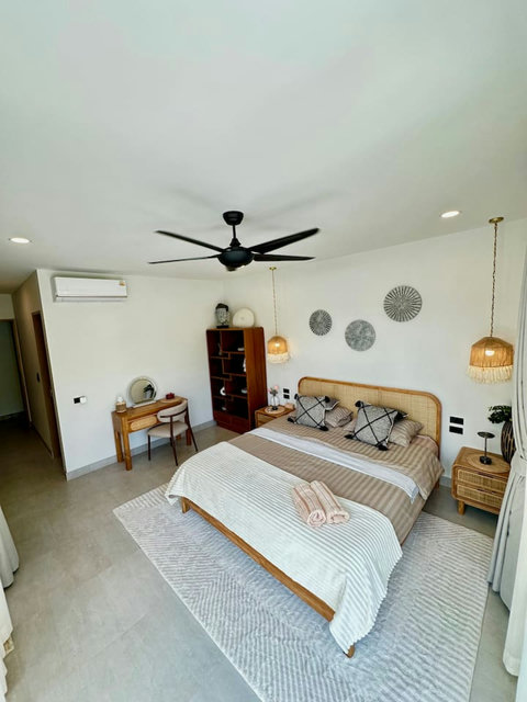 Stylish bedroom with rattan headboard and tropical decor – Villa Amala 3BR pool villa Koh Samui.