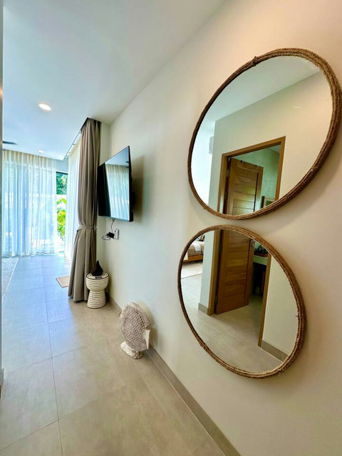 Bedroom dressing area with round mirrors and TV – Villa Amala 3BR pool villa Koh Samui.