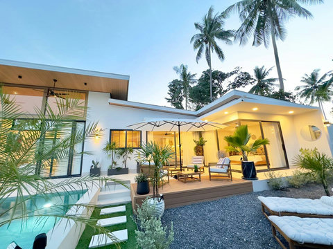 Modern Balinese-style facade of Villa Amala, a 3 bedroom pool villa in Mae Nam, Koh Samui surrounded by palms.