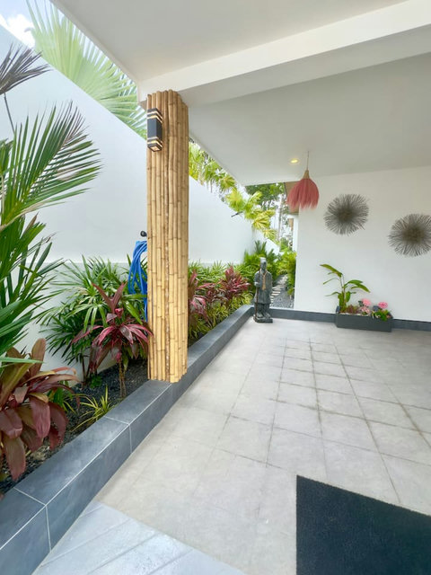Tropical entrance with statue and lush plants at Villa Amala 3BR pool villa Koh Samui.