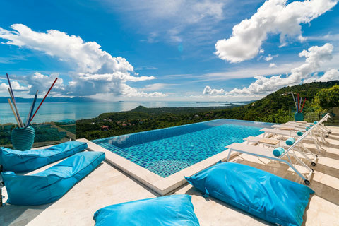 Breathtaking panoramic view featuring the crystal-clear infinity pool blending seamlessly with the endless ocean and lush green hills