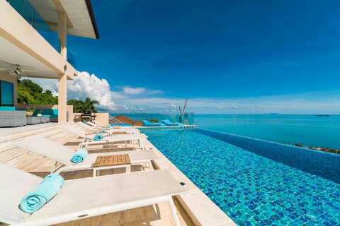 Soak up the sun! The expansive private pool deck features comfortable loungers with an endless ocean backdrop."