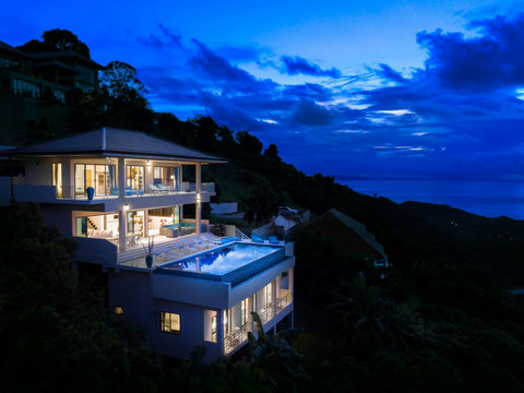 Night View A spectacular night view of the entire villa, beautifully illuminated against the dark tropical hills and the calm sea