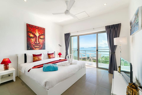 Room N°4 Vibrant and warm bedroom (Room 4) featuring bold artwork, plenty of natural light, and glass doors opening to a private sea-view balcony
