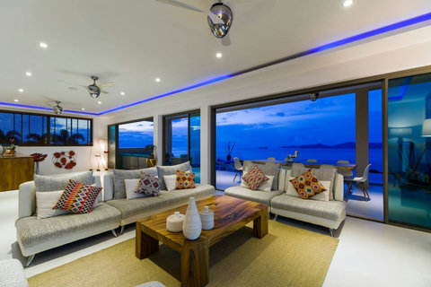 Living Room by Night   The stunning living room transformed at night, blending warm interior lighting with the magical blue hour over the ocean
