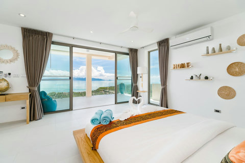 Sun-drenched Master Bedroom featuring massive glass sliding doors that open up to a private balcony with unmatched sea views