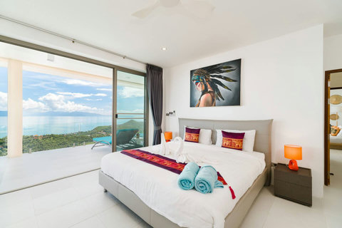 Bright and elegant bedroom (Room 2) offering premium comfort, stylish decor, and a beautiful window overlooking the sea
