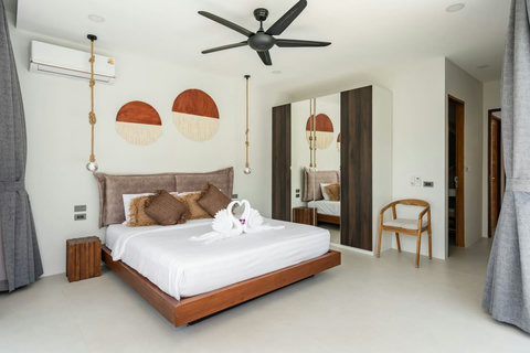 Air-conditioned bedroom with a wood bed frame and woven pendant lights
