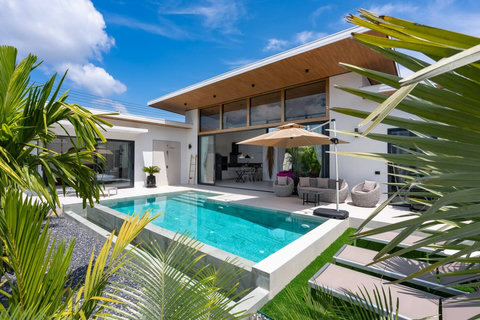 Private swimming pool framed by tropical palms and sun loungers