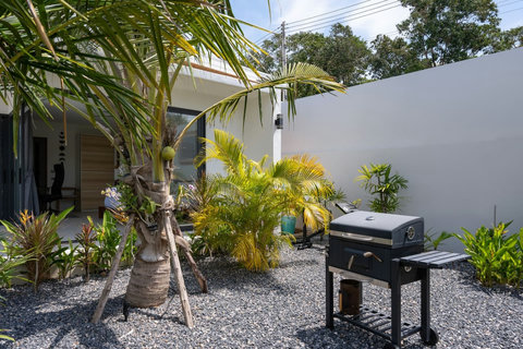 Outdoor barbecue in a palm-lined garden corner
