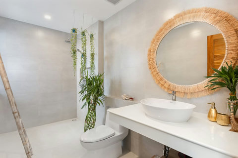 Bathroom with a walk-in shower, vessel basin and woven mirror