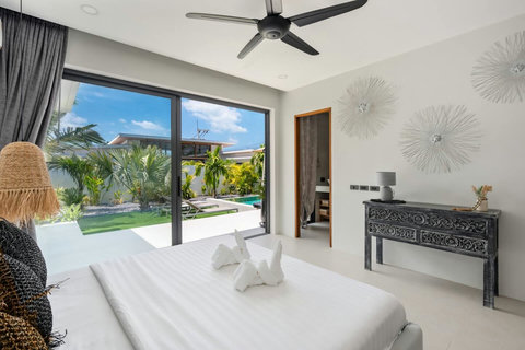 Bright bedroom with sliding glass doors and tropical garden views