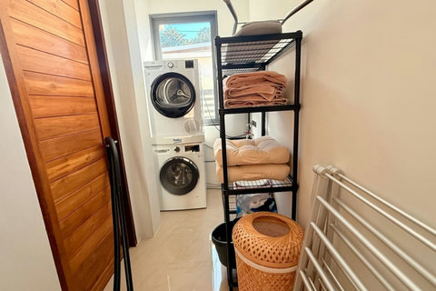 Private laundry area with washing machine, dryer and fresh linens at Villa Jo