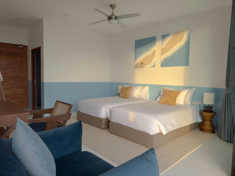 Spacious second bedroom with comfortable twin beds, soft ambient lighting, and elegant minimalist decor. Perfect for kids or friends.