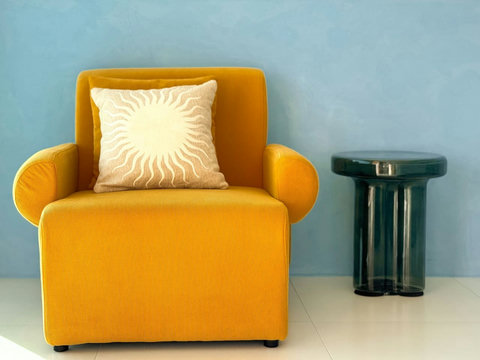 Instaworthy reading nook featuring a statement mustard-yellow velvet armchair and a chic green ceramic side table.