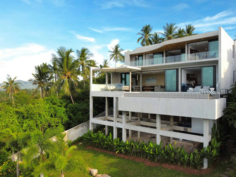 Private hillside pool villa surrounded by coconut trees, greenery, and peaceful tropical views.