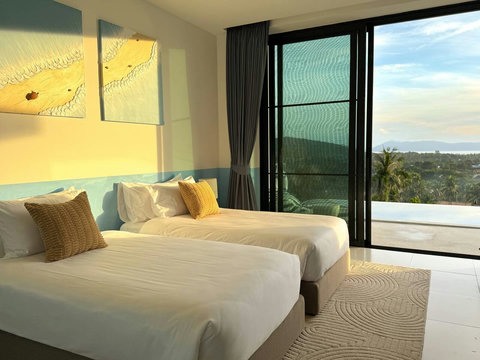 Cozy twin beds bathed in warm, natural afternoon light. Designed with high-quality linens for a restful night's sleep.