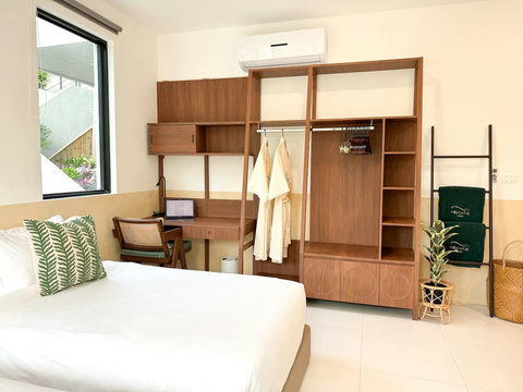 Spacious bedroom with work desk, open wardrobe, bathrobes, and thoughtful guest comforts.