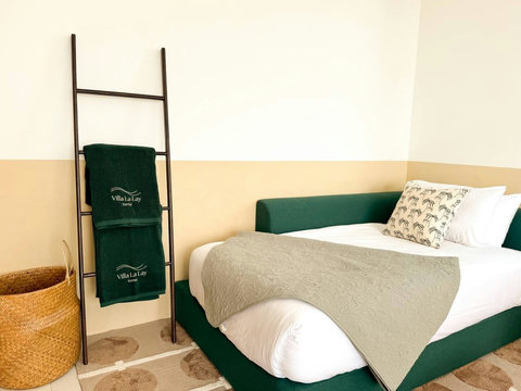 Comfortable green daybed corner featuring our premium custom villa linens. Thoughtful design meets ultimate comfort.