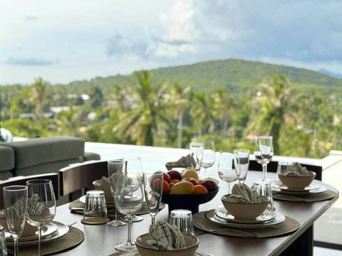 Thoughtfully prepared dining table with glassware, tableware, and tropical welcome details.
