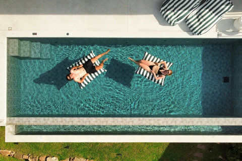 Relax in the private infinity-style pool with comfortable sun loungers and refreshing tropical surroundings.