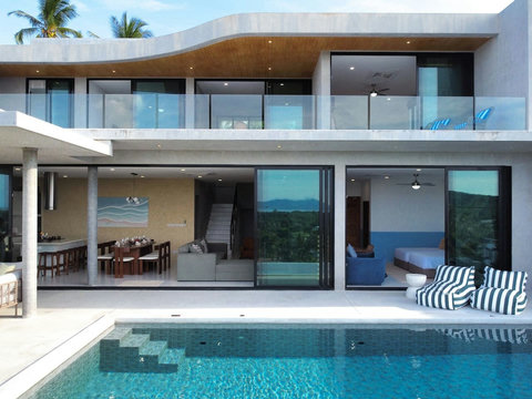 Comfortable open-plan lounge with large sliding doors, natural light, and scenic island views.