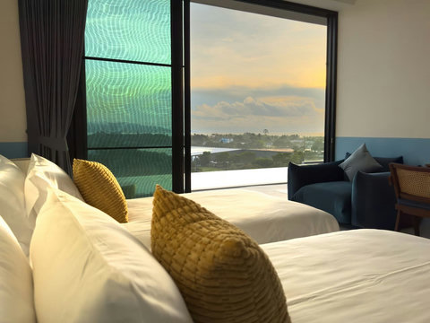 Bright living room featuring panoramic floor-to-ceiling ocean and coastal views. Cozy up on the modern seating and enjoy the sunset.