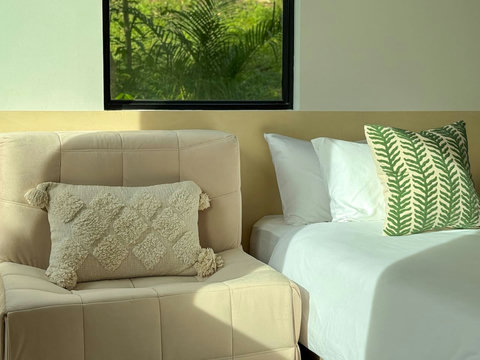 Comfortable premium bedding with fresh linens and tropical-inspired interior design.