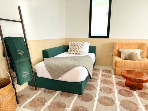 Vibrant bedroom setup featuring a chic orange accent armchair and mid-century modern design elements.